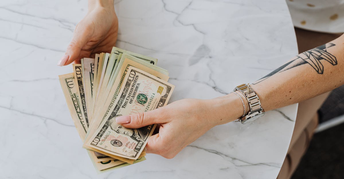 Mãos segurando e contando notas de dólar representando controle financeiro